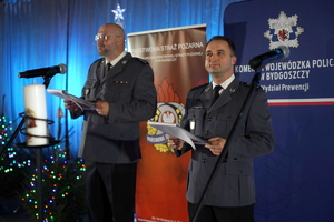 funkcjonariusze i zaproszeni goście biorą udział wydarzeniu związanym z Bezpieczeństwem ze Świętym Mikołajem