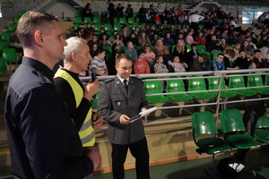 funkcjonariusze i zaproszeni goście biorą udział wydarzeniu związanym z Bezpieczeństwem ze Świętym Mikołajem