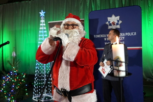 funkcjonariusze i zaproszeni goście biorą udział wydarzeniu związanym z Bezpieczeństwem ze Świętym Mikołajem
