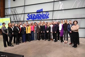 Zdjęcie grupowe osób biorących udział w szkoleniu na tle napisu "Solidarność"