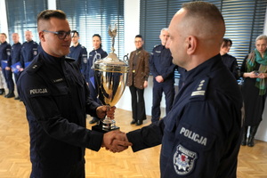 policjant wręcza Komendantowi zdobyty puchar