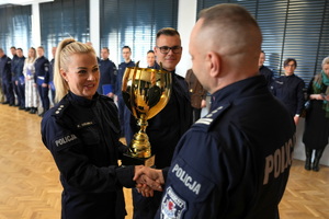 policjant wręcza Komendantowi zdobyty puchar