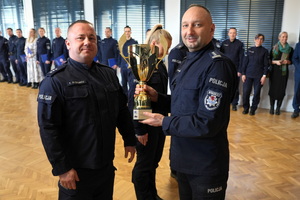 policjant wręcza Komendantowi zdobyty puchar