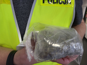 Policjant trzyma woreczek z marihuaną