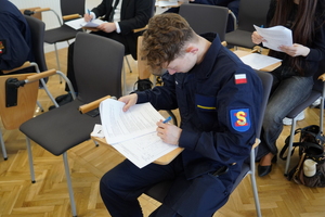 uczniowie siedzą i rozwiązują test