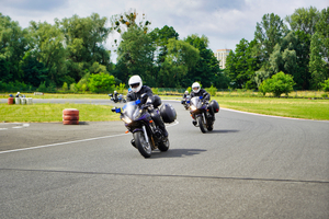 Policjanci jadą na motocyklach służbowych