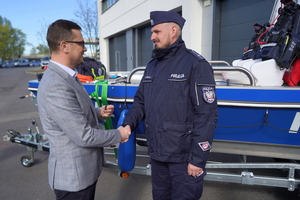 Wojewoda gratuluje i wręcza kluczyki policjantowi