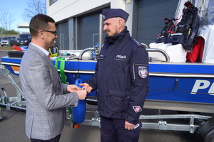Wojewoda gratuluje i wręcza kluczyki policjantowi