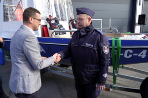Wojewoda gratuluje i wręcza kluczyki policjantowi