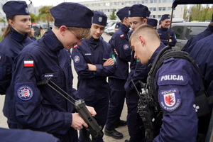 Uczeń w towarzystwie policjanta zapoznaje się z jednostką broni