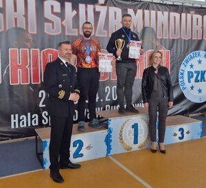 policjanci pozują do zdjęcia z innymi osobami na podium