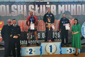 policjanci pozują do zdjęcia z innymi osobami na podium