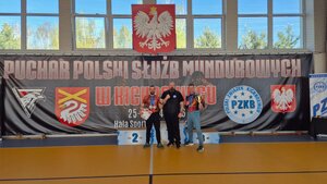 policjanci pozują do zdjęcia z innymi osobami na podium