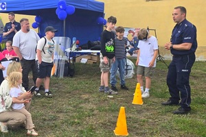 Policjanci na pikniku profilaktycznym, prezentują sprzęt oraz prowadzą gry i zabawy dla dzieci