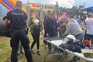 Policjanci na pikniku profilaktycznym, prezentują sprzęt oraz prowadzą gry i zabawy dla dzieci