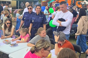 Policjanci na pikniku profilaktycznym, prezentują sprzęt oraz prowadzą gry i zabawy dla dzieci