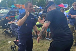 Policjanci na pikniku profilaktycznym, prezentują sprzęt oraz prowadzą gry i zabawy dla dzieci
