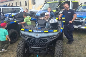 Policjanci na pikniku profilaktycznym, prezentują sprzęt oraz prowadzą gry i zabawy dla dzieci