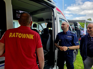 Policjanci w grupie osób na placu.
