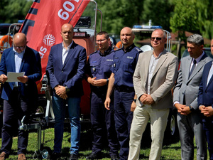 Policjanci w grupie osób na placu.