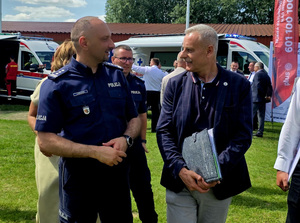 Policjanci w grupie osób na placu.