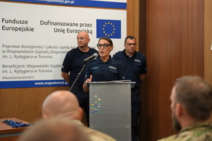 prelegent prowadzi szkolenie i mówi do zaproszonych gości siedzących w sali na krzesłach