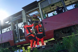 policjanci, ratownicy i strażacy wyciągają i transportują poszkodowanych z tramwaju