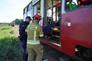 policjanci, ratownicy i strażacy wyciągają i transportują poszkodowanych z tramwaju