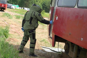 policyjny pirotechnik ubiera specjalistyczny kombinezon i udaje się do tramwajów, gdzie sprawdza podejrzane pakunki