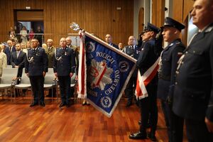 Pierwszy Zastępca Komendanta Wojewódzkiego Policji stoi w towarzystwie  Komendantów Miejskiego w Grudziądzu i Powiatowego w Chełmnie przed poczet sztandarowy.