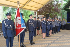 Policjanci stoją w szeregach obok poczet sztandarowy