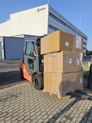 widlak przewozi kartony z kaskami