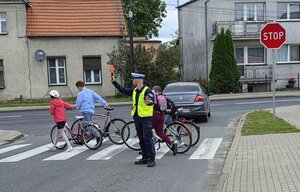 Policjanci oraz policyjna maskotka "Polfinek" podczas akcji "Bezpieczna droga do szkoły"