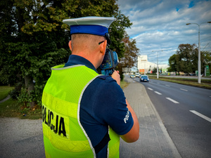 Policjant mierzy prędkość i kontroluje kierowców