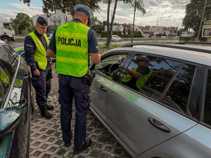 Policjant mierzy prędkość i kontroluje kierowców