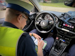 Policjant mierzy prędkość i kontroluje kierowców