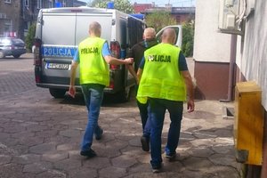 policjanci doprowadzają zatrzymanego do radiowozu