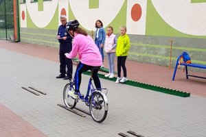 dziecko przejeżdża na rowerze pomiędzy dwoma deskami