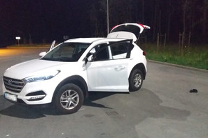 zabezpieczony biały Hyundai Tucson z otwarta klapą bagażnika