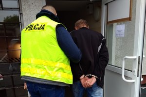 policjant prowadzi zatrzymanego