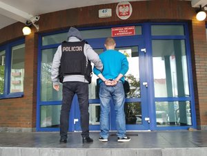 policjant prowadzi zatrzymanego do KMP w Bydgoszczy