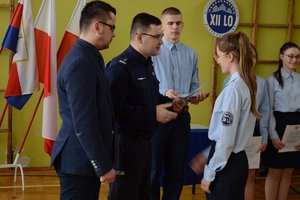 p.o. Zastępcy Komendanta Miejskiego w Bydgoszczy mł. insp. Mariusz Sobiecki oraz Dyrektor Zespołu Szkół nr 24 mgr inż. Leszek Sobieraj wręczają nominacje uczennicy szkoły.