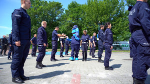 policjanci wrzucają pieniądze do puszki, którą trzyma Polfinek