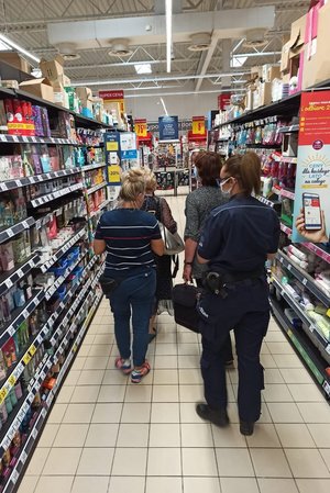 policjantka stoi obok klientów sklepów