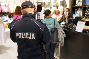 policjant i dwie pracownice sanpeidu kontrolują jeden z sklepów w galerii handlowej