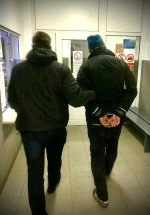 policjant prowadzi zatrzymanego