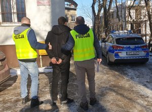 Policjanci prowadzą zatrzymanego do komisariatu na Szwederowie.