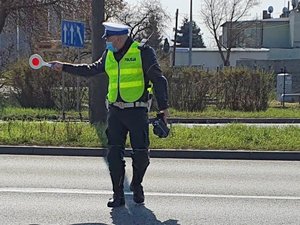 policjant daje znak do zatrzymania na ulicy