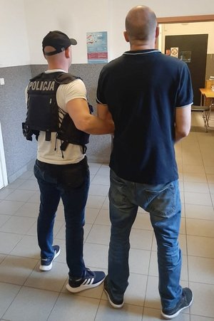 policjant trzyma zatrzymanego