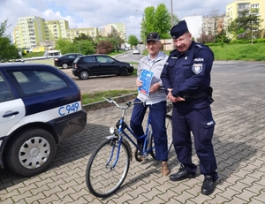 policjant podczas rozmowy z seniorem- rowerzystą na osiedlu